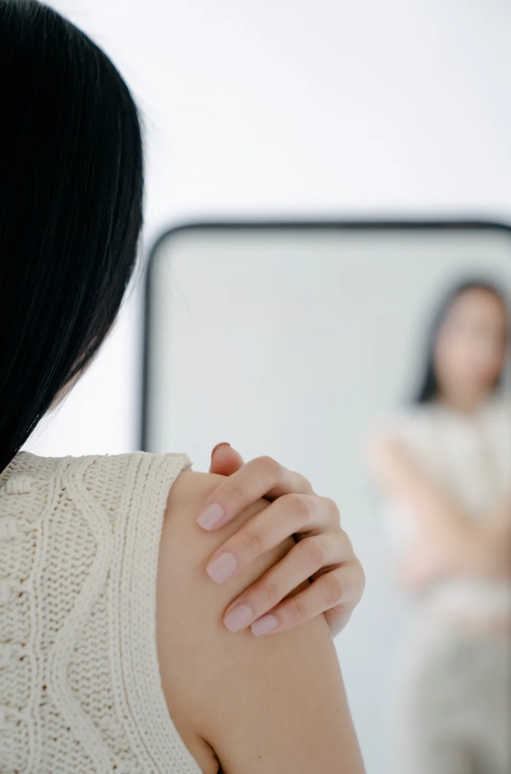 Mujer con molestias en el hombro tocándose la articulación