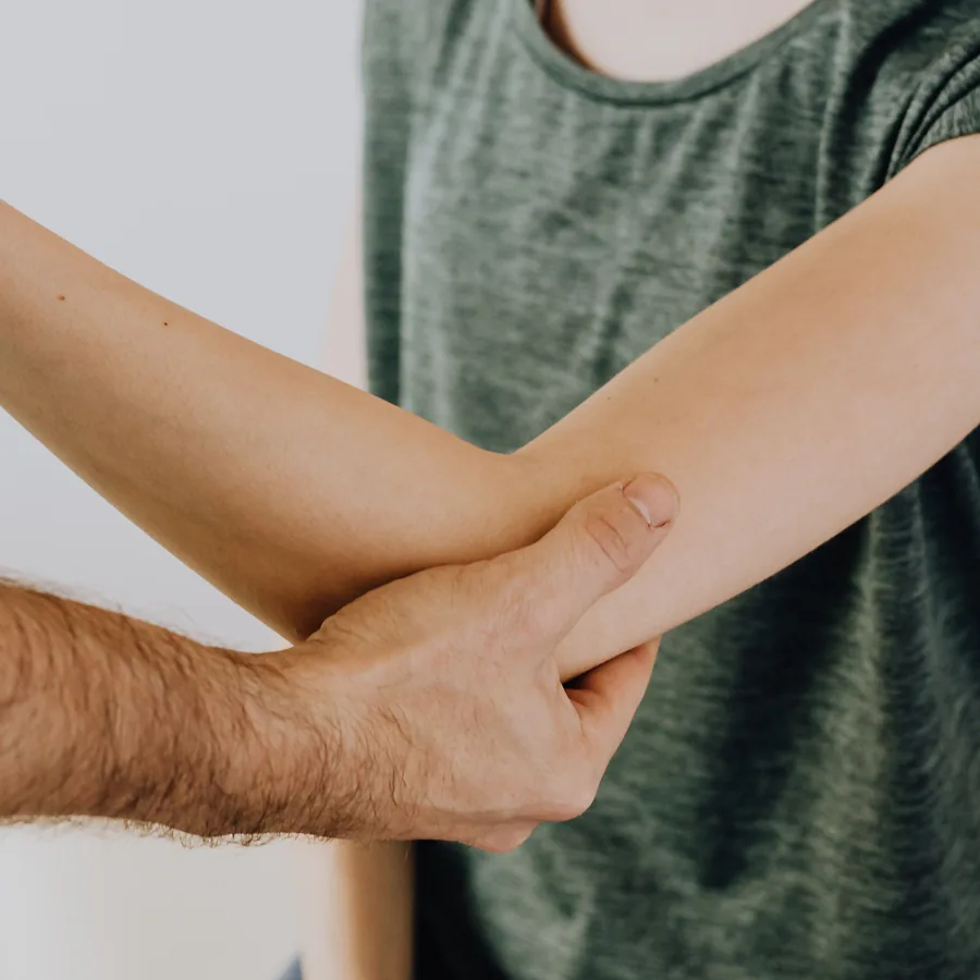 Exploración del codo por el traumatólogo en consulta en Valencia
